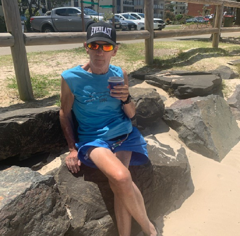 RCS Participant Chris on the beach with a coffee